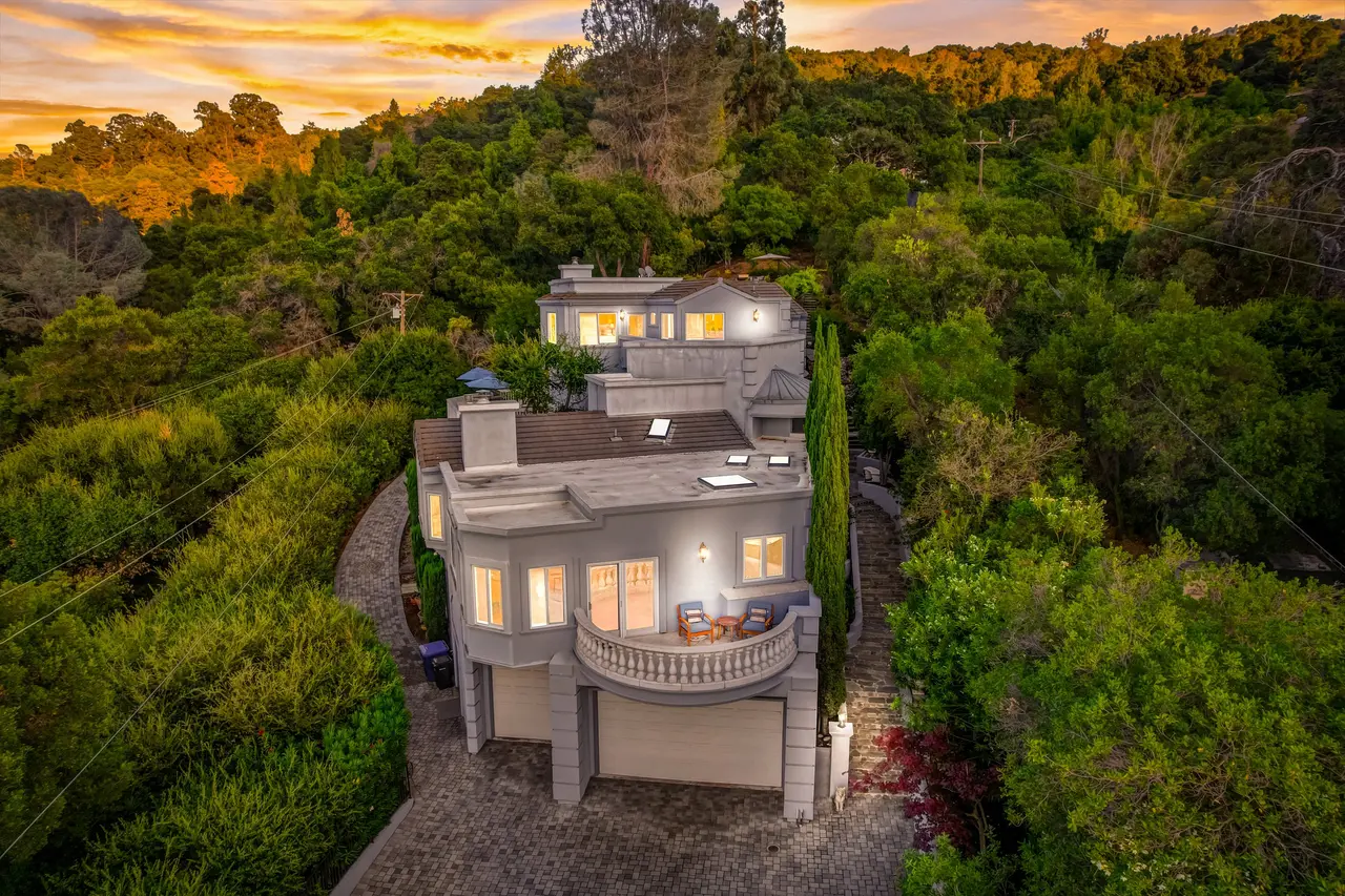 Aerial view at sunset of the home surrounded by oaks and redwoods