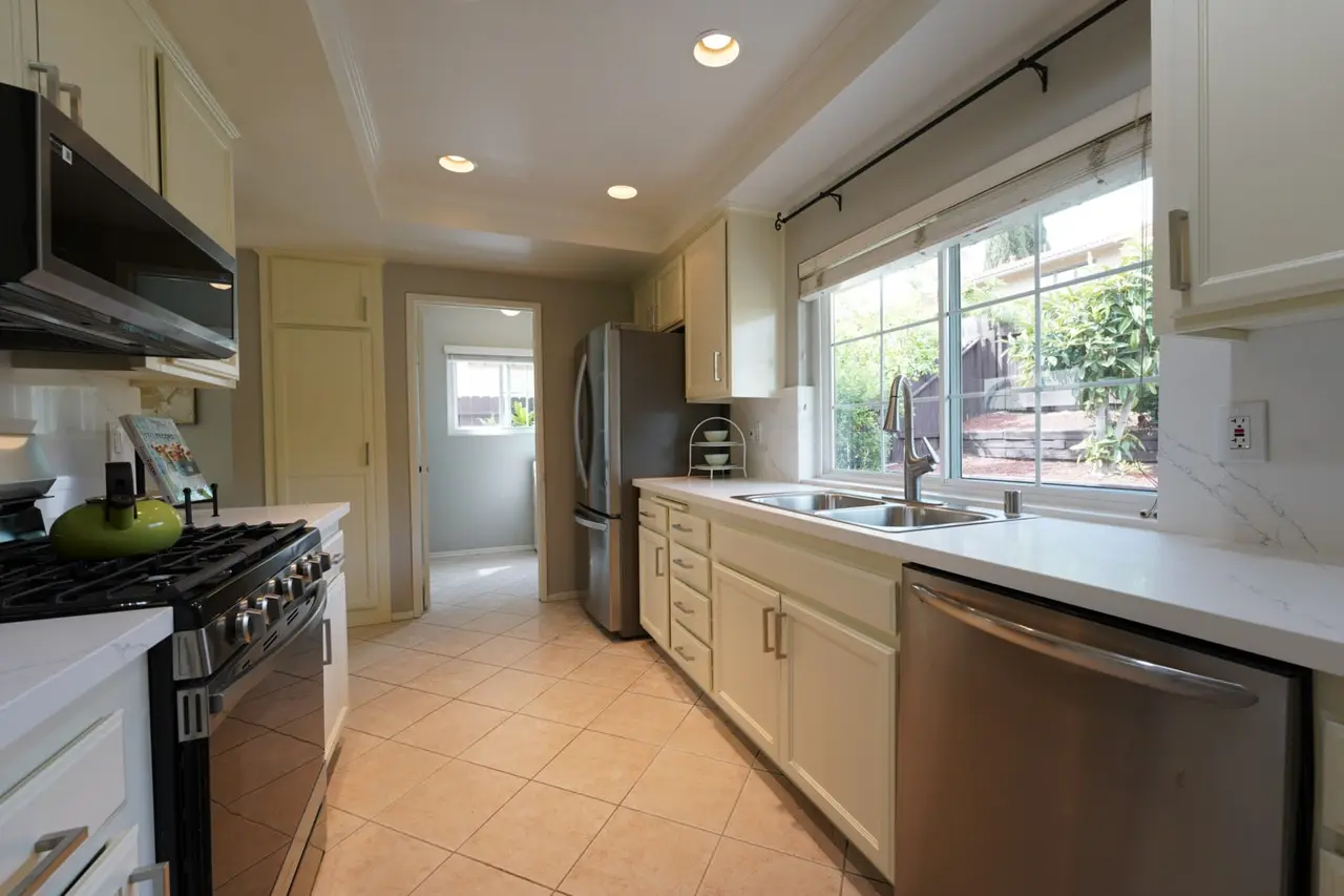 Kitchen with a gas range and a window looking out to the terraced backyard