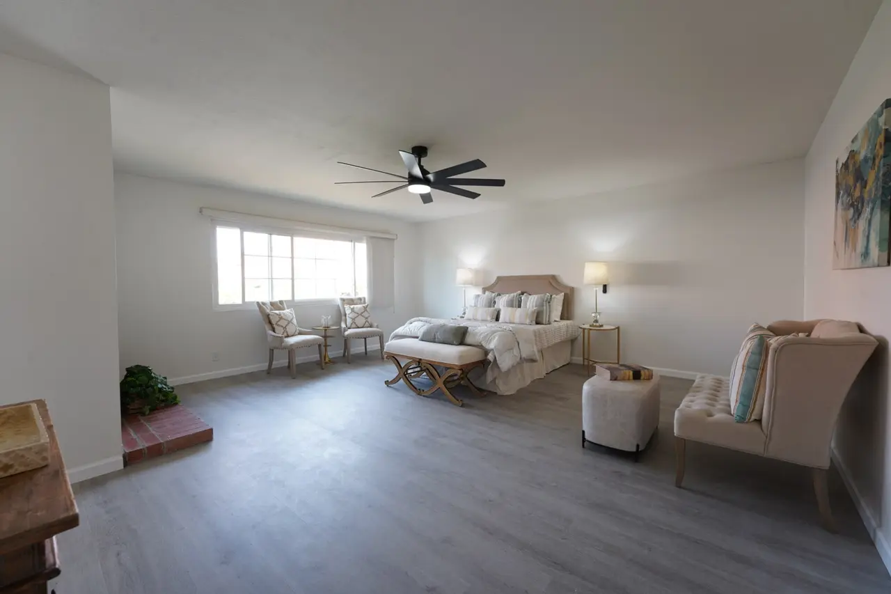 Primary bedroom with a ceiling fan and a wide window