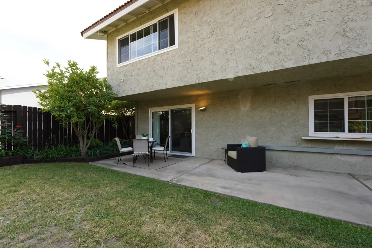 Backyard with a lawn and a patio along the back of the home