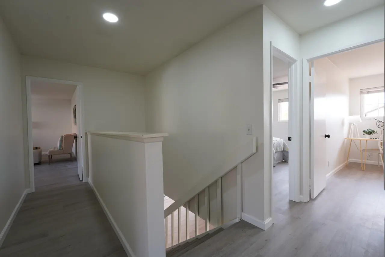Upstairs hallway with the stair railing and doors to the bedrooms